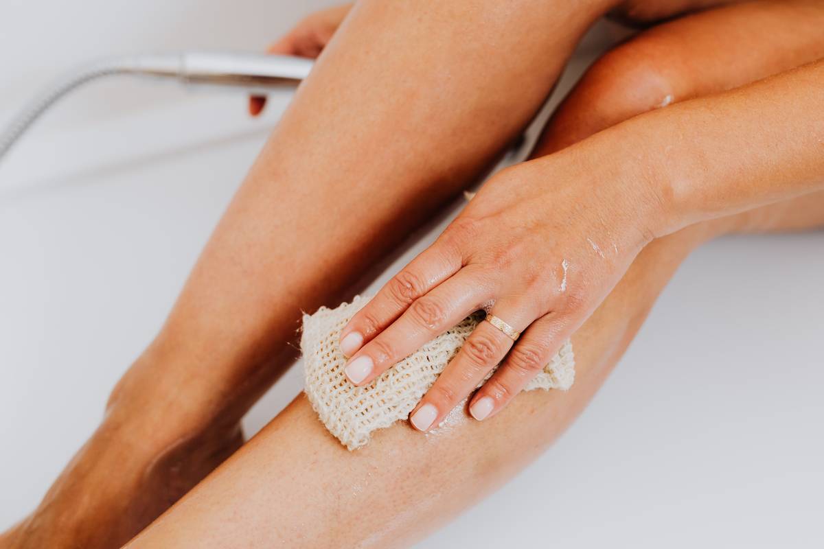 Woman examining cellulite cream at ulta packaging on a bathroom counter